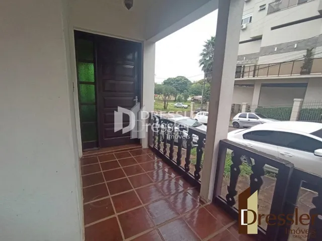 Hall de entrada com piso de cerâmica e porta de madeira.