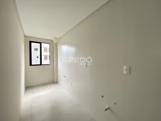 Corredor interno de uma residência com paredes brancas e piso claro.