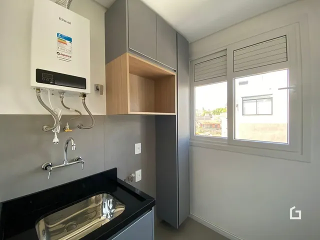 Uma cozinha moderna com armários cinzas e janela.