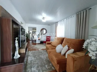 Sala de estar com sofá marrom e detalhes em madeira.