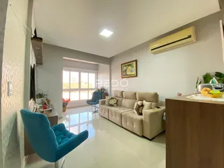 Sala de estar moderna com sofá e poltrona azul em um apartamento.