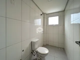 Foto de um banheiro com revestimento cerâmico branco.