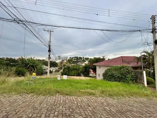 Vista externa de uma residência com gramado e vegetação no primeiro plano.