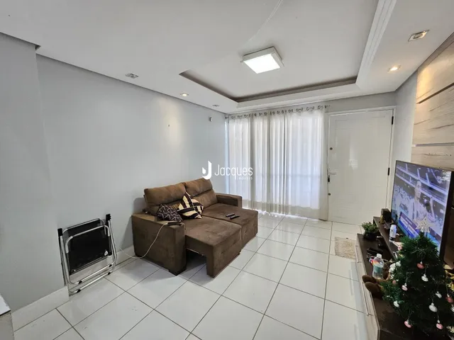 Sala de estar moderna com piso de cerâmica e sofá em um imóvel no Brasil.