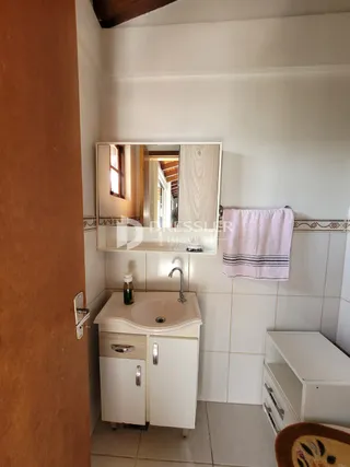 Foto de um banheiro com bancada e azulejos brancos.