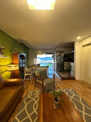 Sala de estar com piso de madeira e área de jantar.