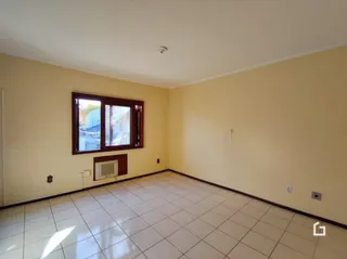 Quarto interno com piso de cerâmica e janela de madeira.