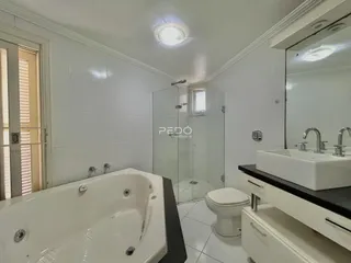 Banheiro com box de vidro e banheira em um imóvel.
