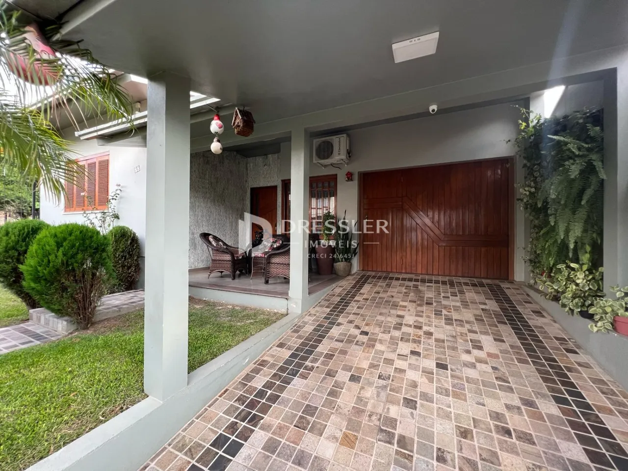 Fachada externa da propriedade com piso de ladrilhos no pátio.