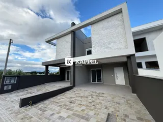 Fachada moderna de uma residência em Lajeado, Brasil, com área externa pavimentada.