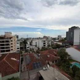 Vista da cobertura com telhas de terracota e vegetação.