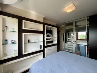 Quarto com paredes escuras e estantes brancas em um imóvel no Brasil.