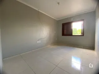 Ambiente interno de uma sala com piso de cerâmica e janela.
