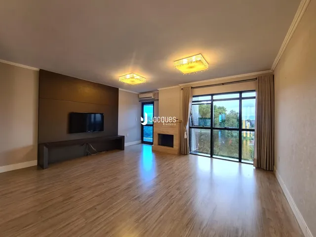Sala de estar ampla com piso de madeira e grandes portas de vidro.