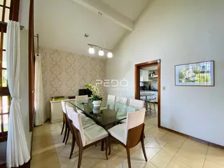 Sala de jantar com mesa de vidro e cadeiras em um imóvel no Brasil.