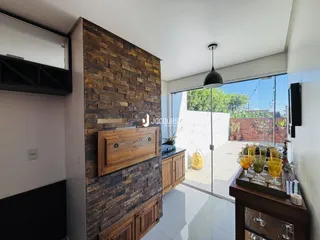 Interior de uma sala com parede de pedra e porta de vidro para o exterior.