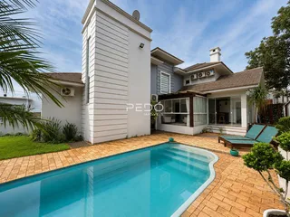 Vista da fachada de uma casa com piscina e área externa.