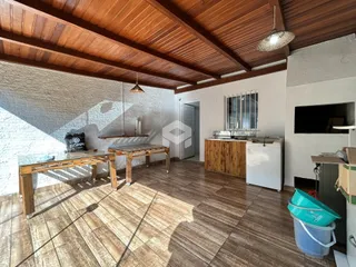 Ambiente interno de uma sala com piso de madeira e teto de madeira.