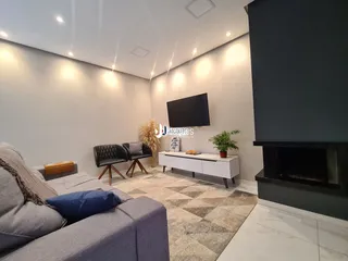 Sala de estar moderna com lareira e sofá cinza.