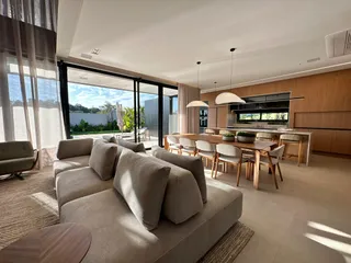 Sala de estar com sofá grande e portas de vidro que dão vista para o exterior.