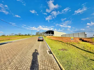 Vista externa de uma propriedade com estrada e área gramada.