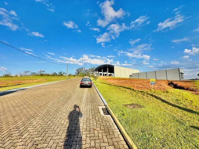 Vista externa de uma propriedade com estrada e área gramada.
