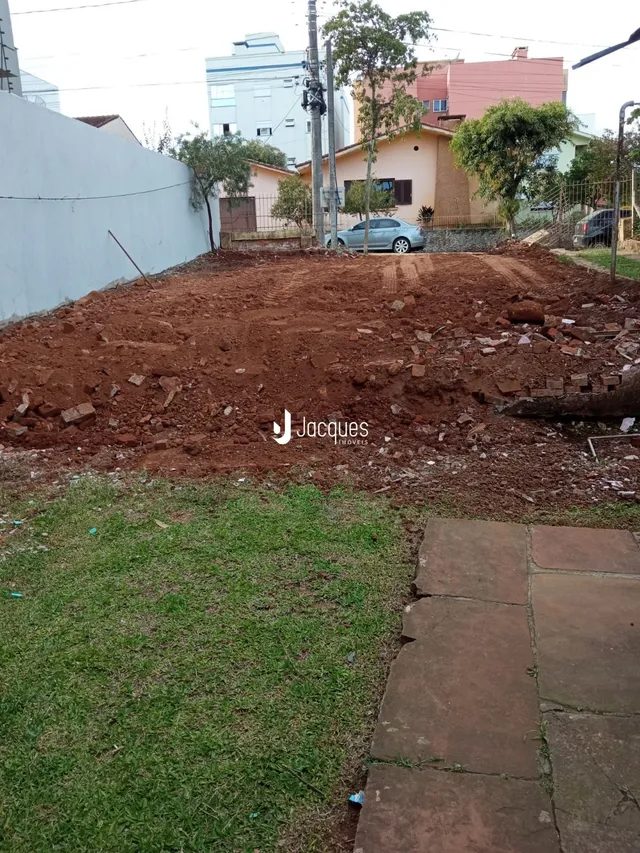 Vista externa de um terreno com terra revolvida e grama no primeiro plano.