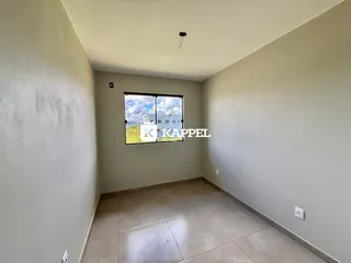Uma sala com piso de cerâmica e uma janela que dá para a paisagem.