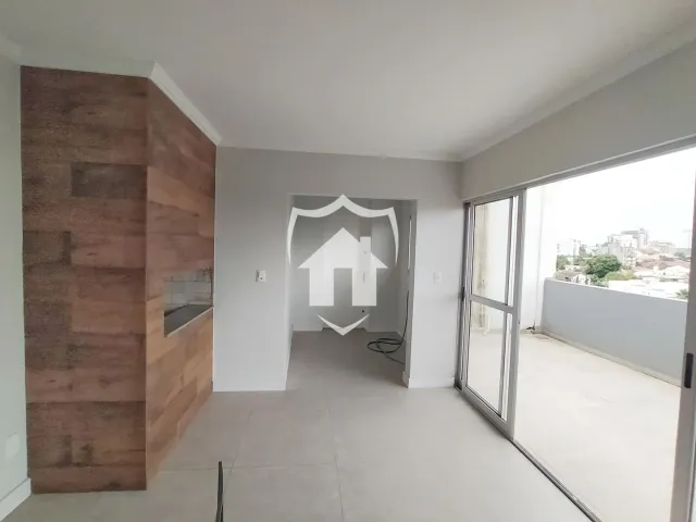 Interior de uma sala com parede de madeira e porta de acesso a outra área.