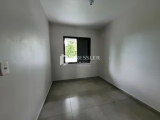 Foto de um cômodo interno com paredes brancas e piso de cerâmica.