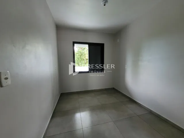 Foto de um cômodo interno com paredes brancas e piso de cerâmica.