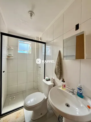 Foto de um banheiro com revestimento de azulejos brancos e pia.