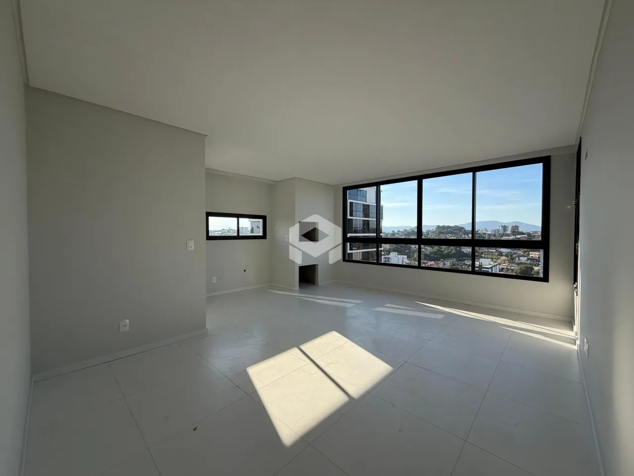 Sala ampla com vista para a paisagem da cidade.