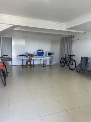 Foto de um ambiente interno amplo com piso de cerâmica e mesa de jantar.