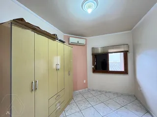 Quarto com armário grande e piso de cerâmica claro.