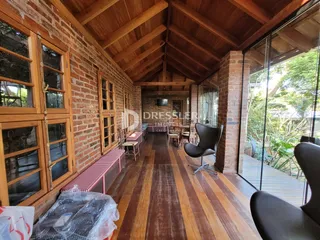 Interior de uma casa com paredes de tijolo aparente e piso de madeira.
