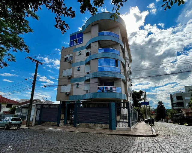 Fachada de um prédio residencial em Lajeado, Brasil, sob um céu azul.