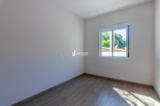 Foto de um cômodo interno com piso de madeira e parede branca.