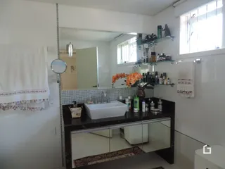 Uma cozinha com armários escuros e bancada branca.