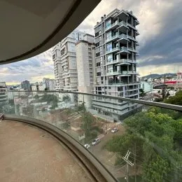 Vista externa de um prédio residencial alto em Lajeado, Brasil, com vegetação ao redor.