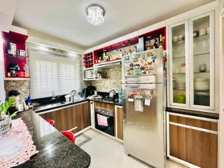 Cozinha moderna com armários de madeira e eletrodomésticos em aço inoxidável.