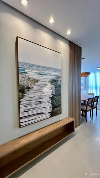 Uma parede com uma pintura grande e um banco de madeira.
