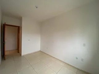 Foto de um corredor interno com piso de cerâmica clara.