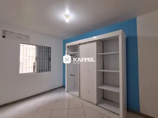 Foto de um corredor interno com paredes brancas e piso de cerâmica.