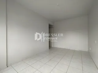 Ambiente interno de uma sala com piso de cerâmica branca.