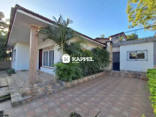 Fachada de uma residência em Lajeado, Brasil, com área externa pavimentada e vegetação.
