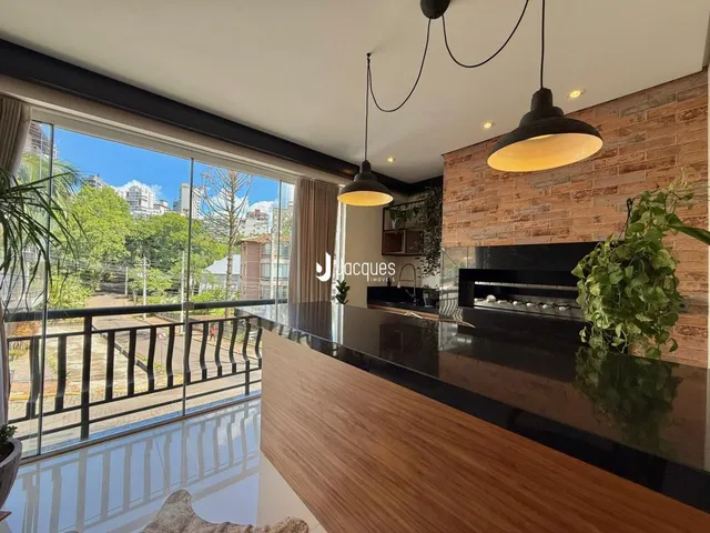 Vista de uma sala de estar com grande janela e decoração moderna em um imóvel no Brasil.