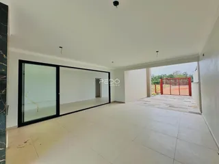 Sala de estar com portas de vidro abrindo para o pátio externo.