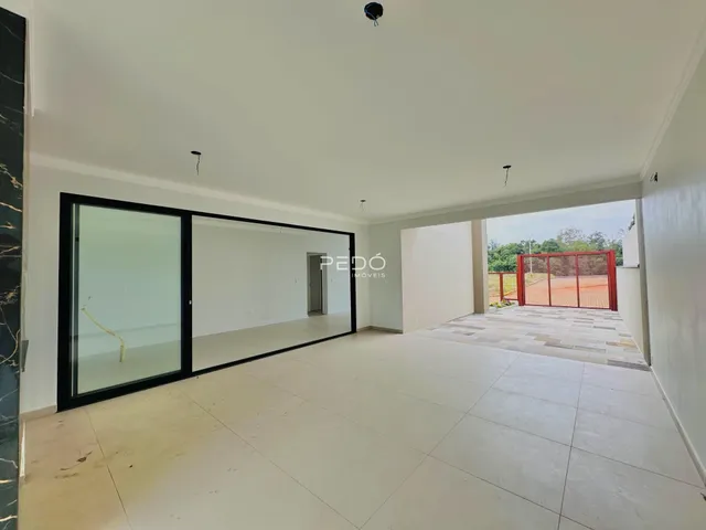 Sala de estar com portas de vidro abrindo para o pátio externo.