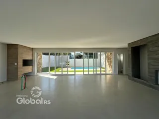 Sala ampla com portas de vidro que dão para o quintal.